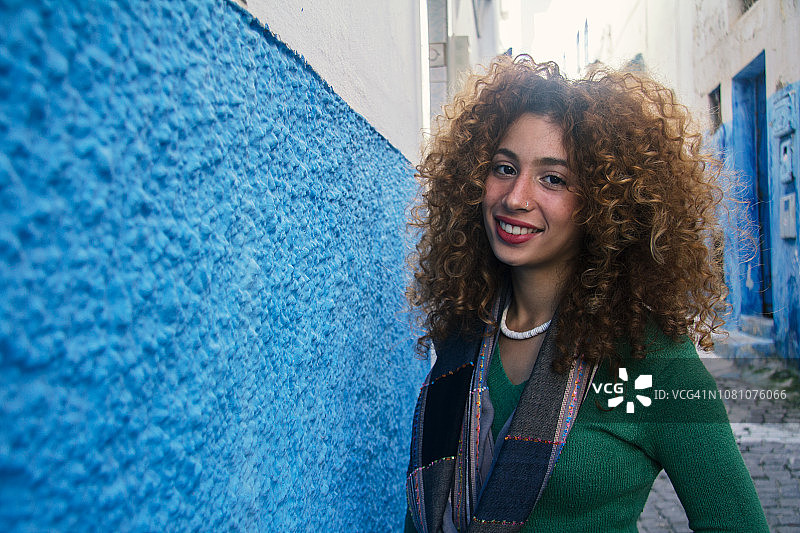 笑容满面的卷发年轻女子图片素材