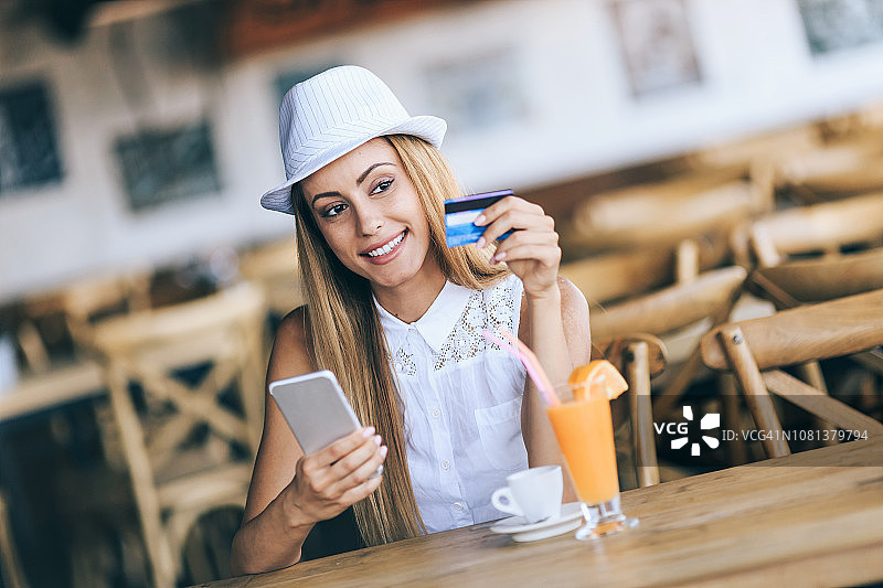 手持信用卡和智能手机的女孩图片素材