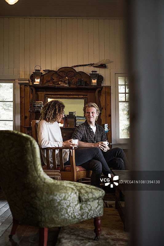 年轻夫妇在山间小屋度假图片素材