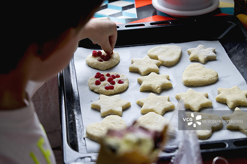 男孩在家制作浆果饼干特写图片素材