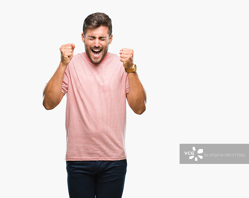 在孤立背景下，年轻英俊的男子兴奋地举起双臂庆祝胜利，面带微笑图片素材