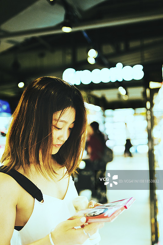 年轻的亚洲女人在超市购物图片素材