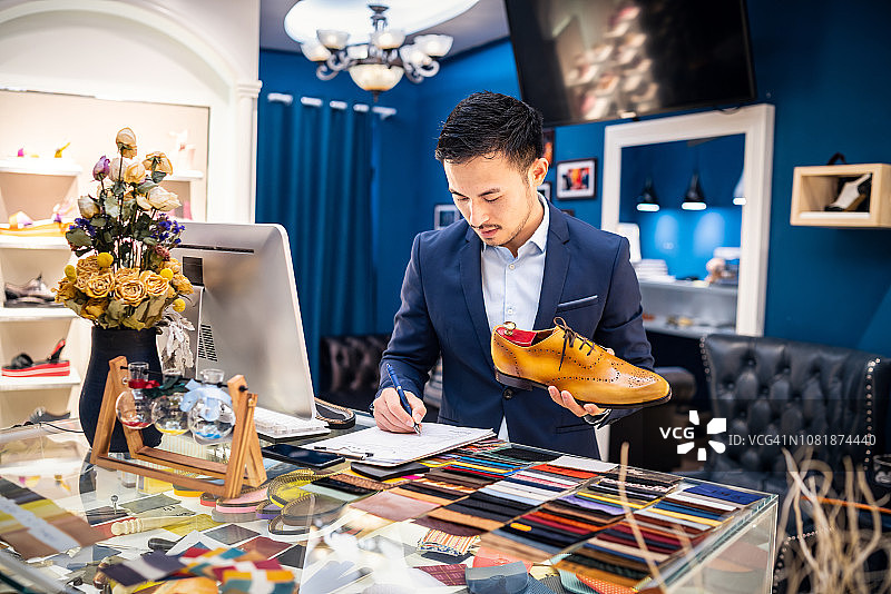 书写记事本的中国鞋店店主图片素材