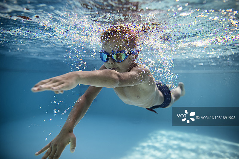 在泳池里练习爬泳的小男孩图片素材