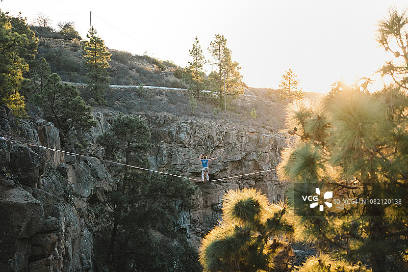 日落时分，男子在高山之上走扁带图片素材
