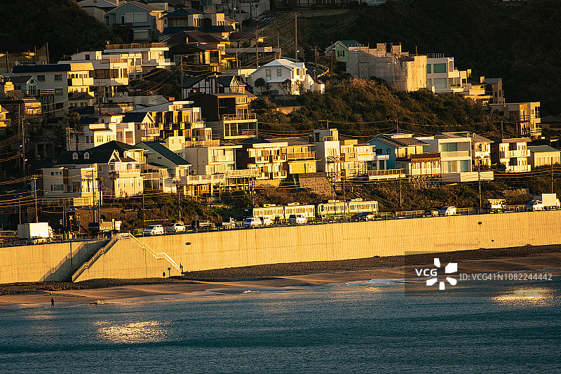 江之电在晨曦照耀下的镰仓市金色海岸线上行驶（日本神奈川县）图片素材