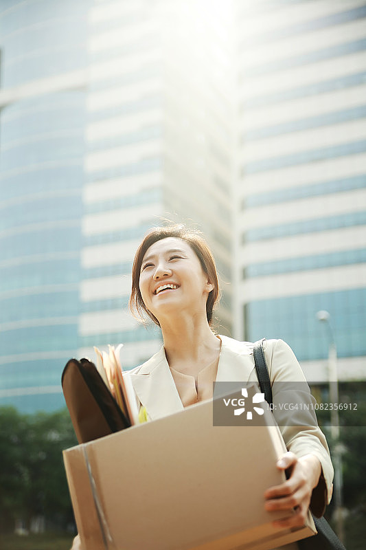 微笑的女商人抱着一箱个人物品图片素材