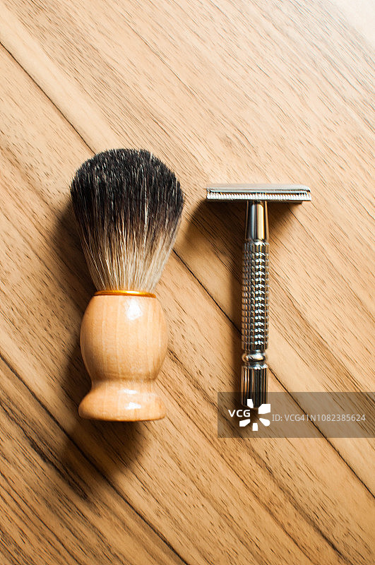 獾毛刷和剃须刀在木桌上图片素材
