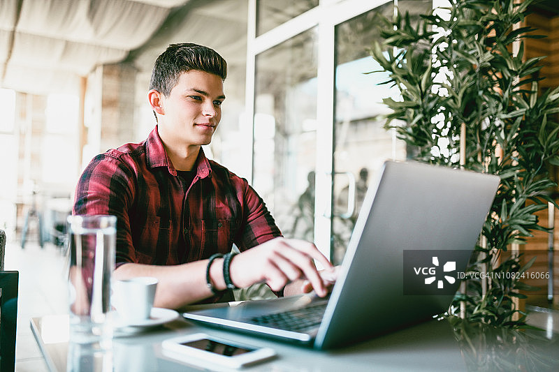 在咖啡馆使用笔记本电脑工作图片素材