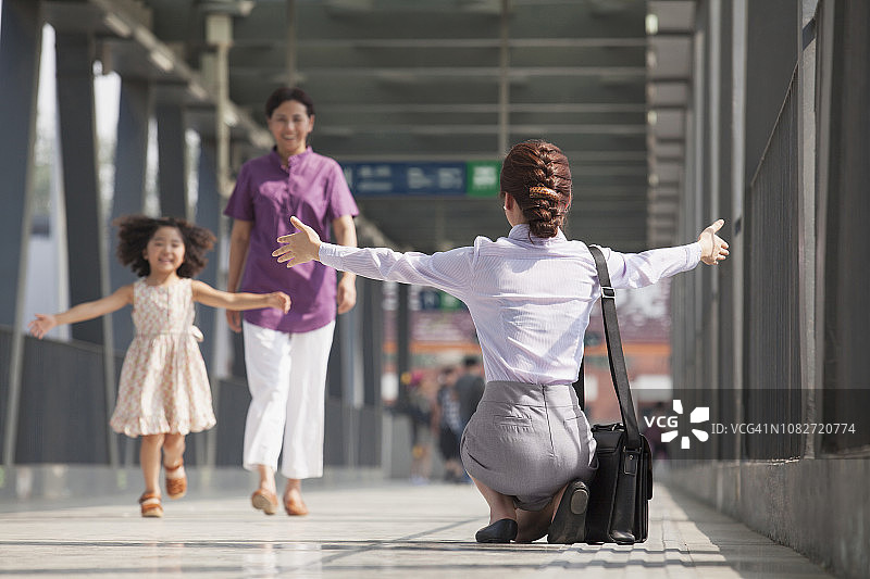 中国女商人在火车站台上迎接女儿图片素材