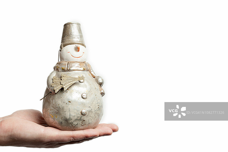 站在男人手上的雪人玩偶，头戴桶帽，手持圣诞树，白色背景，圣诞节装饰，新年概念图片素材