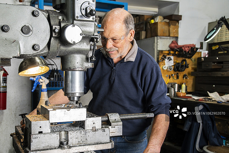 机械师在机加工车间操作传统非数控铣床图片素材