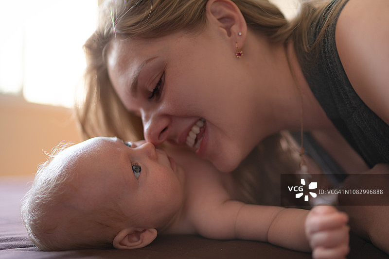 母亲在家照顾新生儿子图片素材