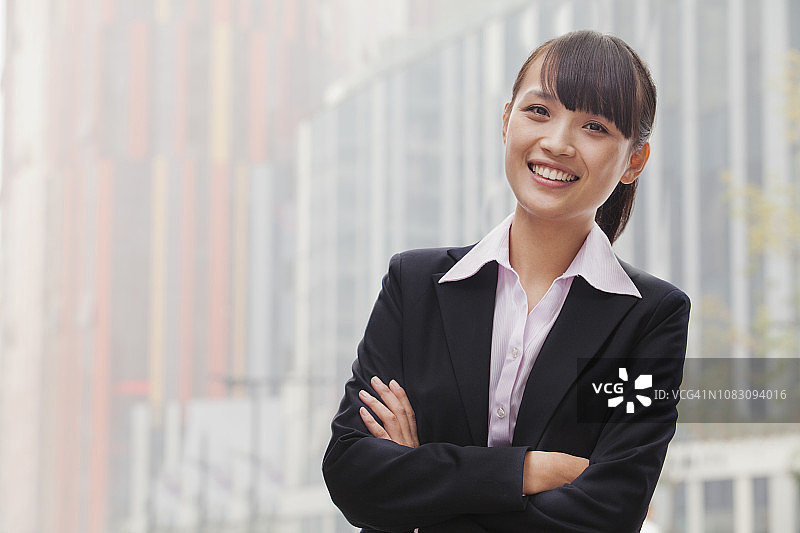 面带微笑的中国女商人，双臂交叉图片素材