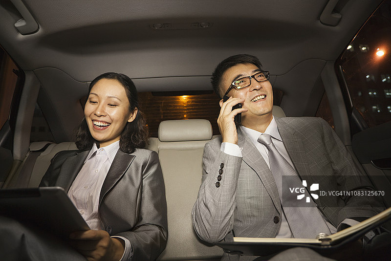 在汽车后座工作的中国商人图片素材