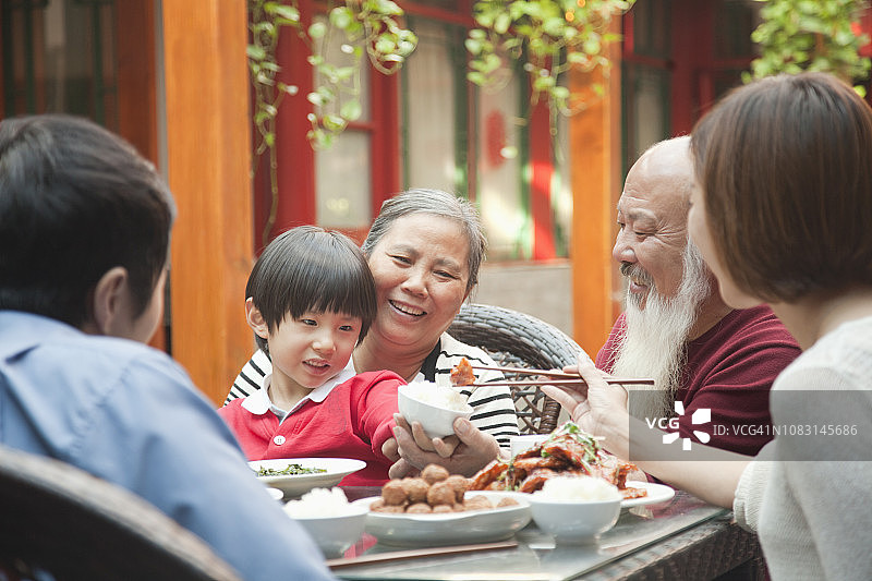 中国家庭在户外餐桌旁用餐图片素材