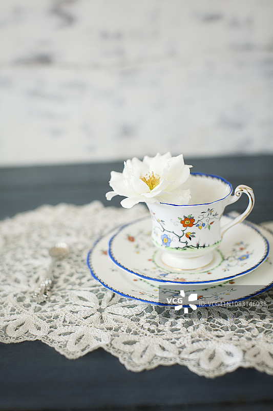复古茶杯三重奏与单支白色玫瑰图片素材