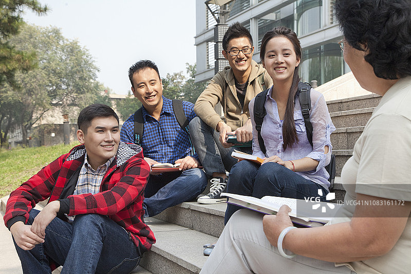 中国老师在校园里和学生交谈图片素材