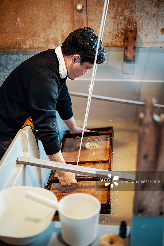 用传统方法造纸的中年日本男子图片素材