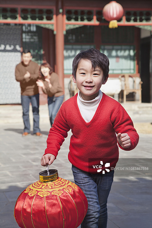 提着传统灯笼的中国男孩图片素材
