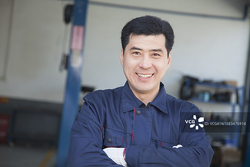 双手交叉站立的中国修理工图片素材