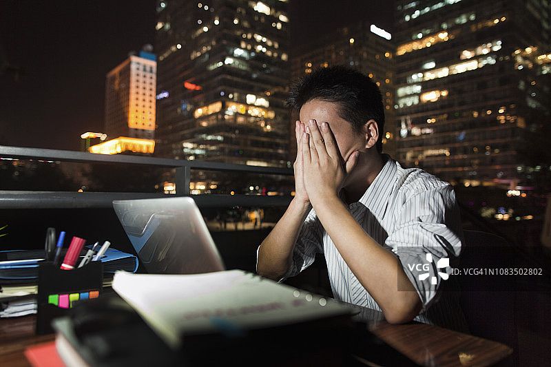 夜晚在办公桌前工作的中国商人图片素材