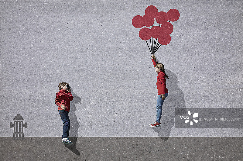 男孩拍摄拿着想象中彩绘气球的女孩图片素材