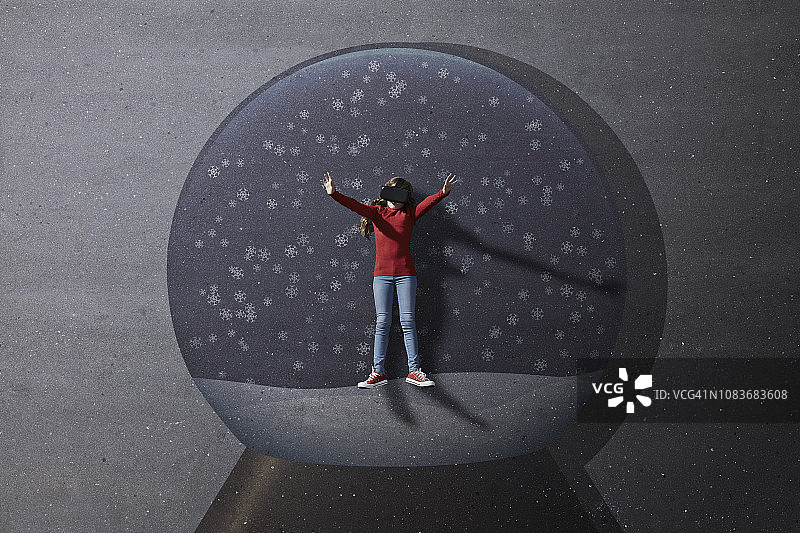 女孩站在想象的圣诞雪景球里图片素材