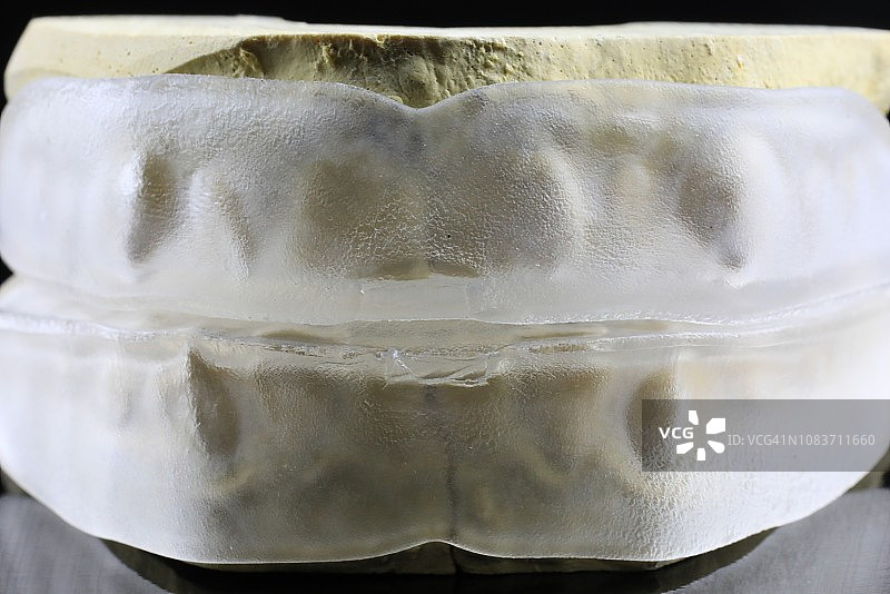 石膏牙齿模型上的牙齿美白托盘图片素材