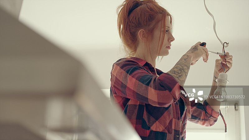 在新家中更换灯泡的女士图片素材