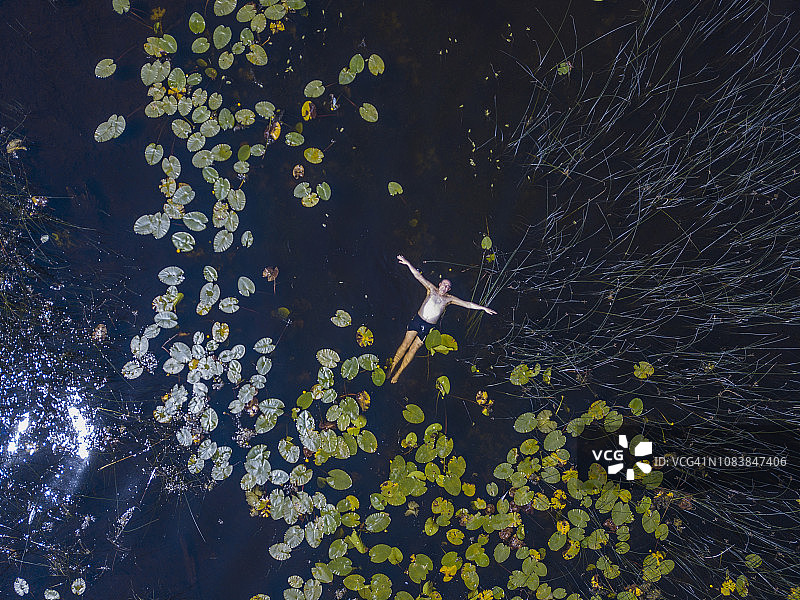 航拍：夏季爱尔兰罗斯康芒湖中游泳的男子图片素材