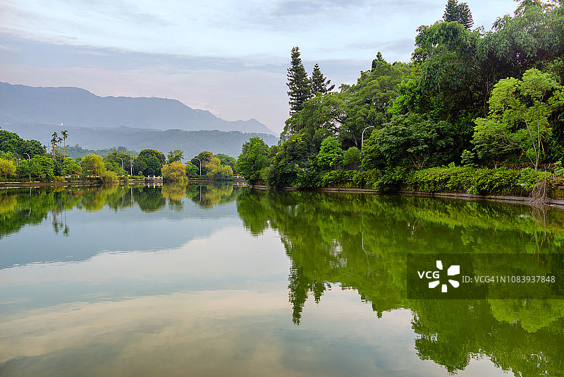 绿树环绕的湖中倒影图片素材