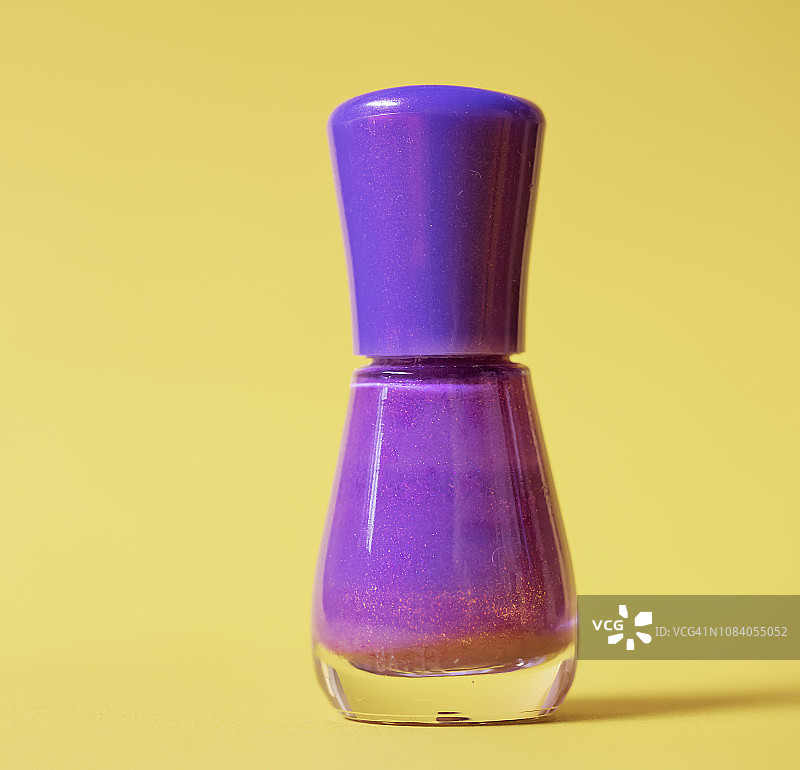 白色背景上的紫色指甲油瓶图片素材