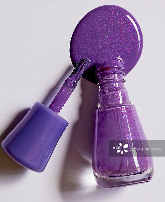 白色背景上的紫色指甲油瓶图片素材