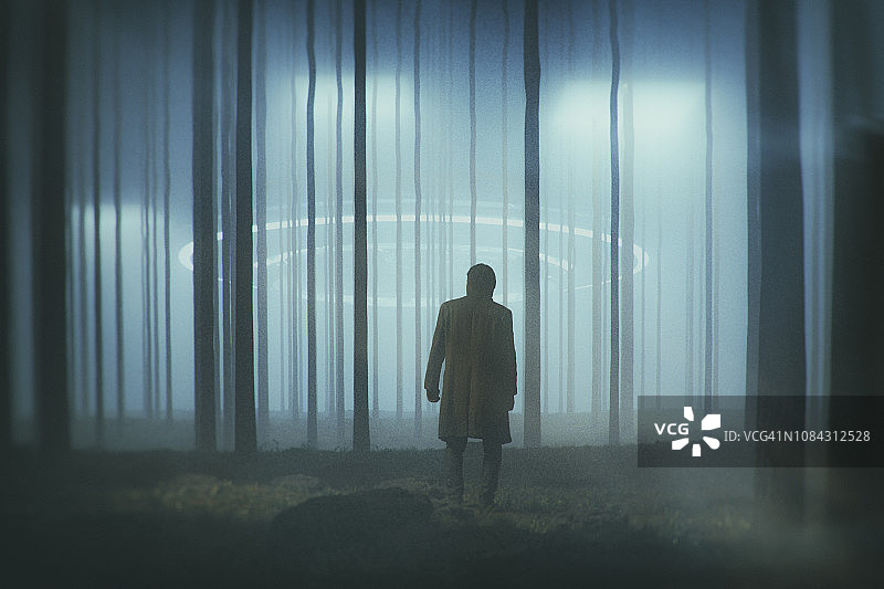 夜晚森林中与着陆UFO的男人图片素材