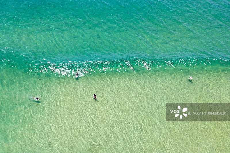 努沙国家公园旁阳光海滩海中冲浪者航拍图片素材