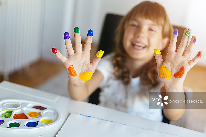 女孩展示涂满颜色的双手图片素材