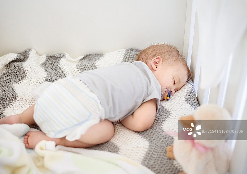 在婴儿床中安静睡眠的新生儿图片素材