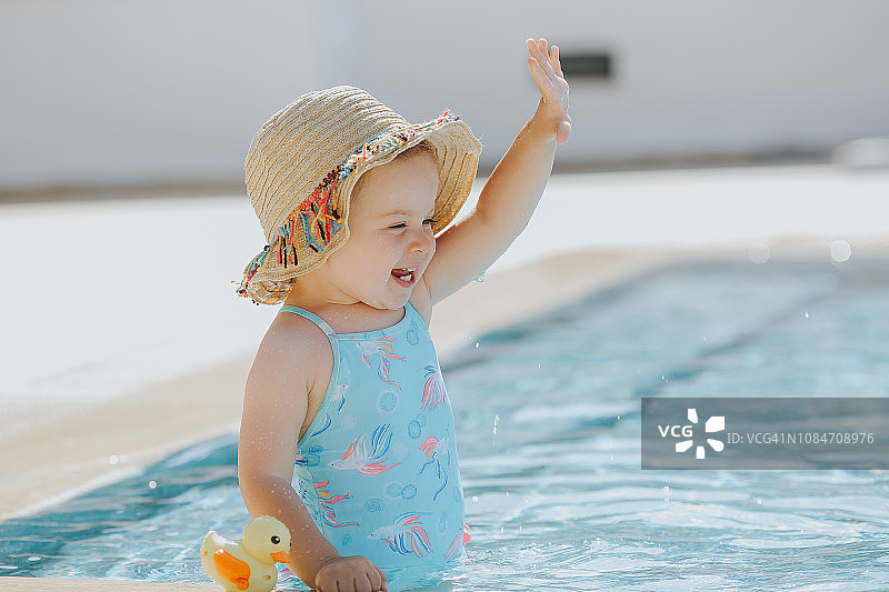 在游泳池里快乐大笑的幼儿女孩图片素材