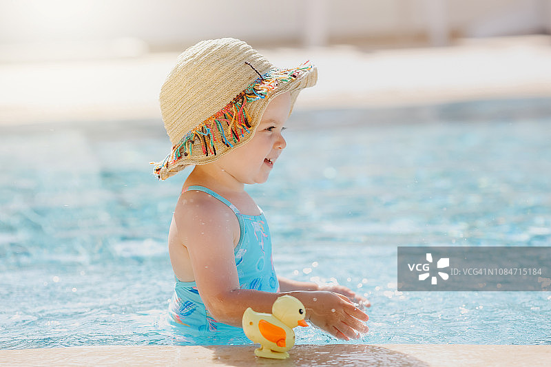 在游泳池里快乐大笑的幼儿女孩图片素材