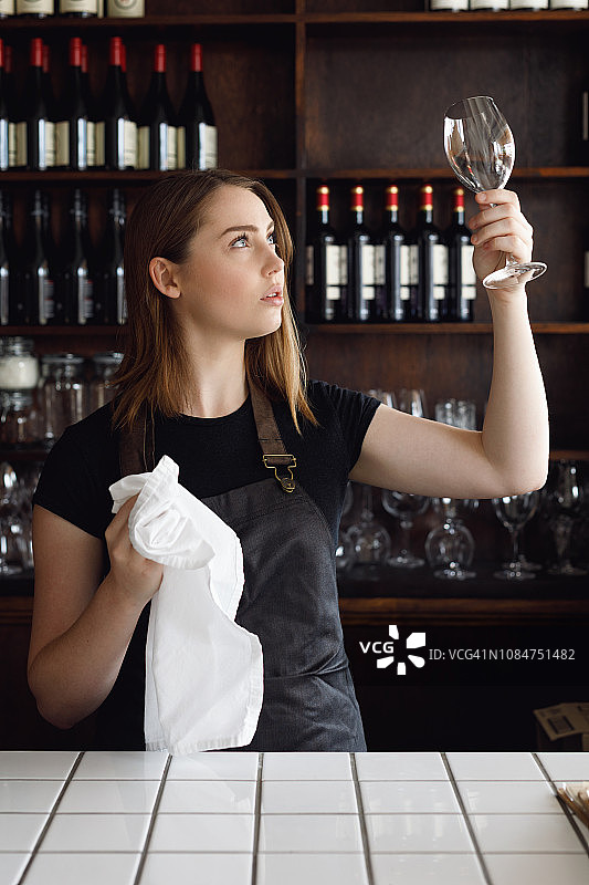 在酒吧清洁酒杯的女服务员图片素材
