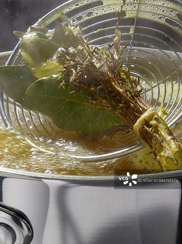 用撇沫器从平底锅中取出香料束图片素材