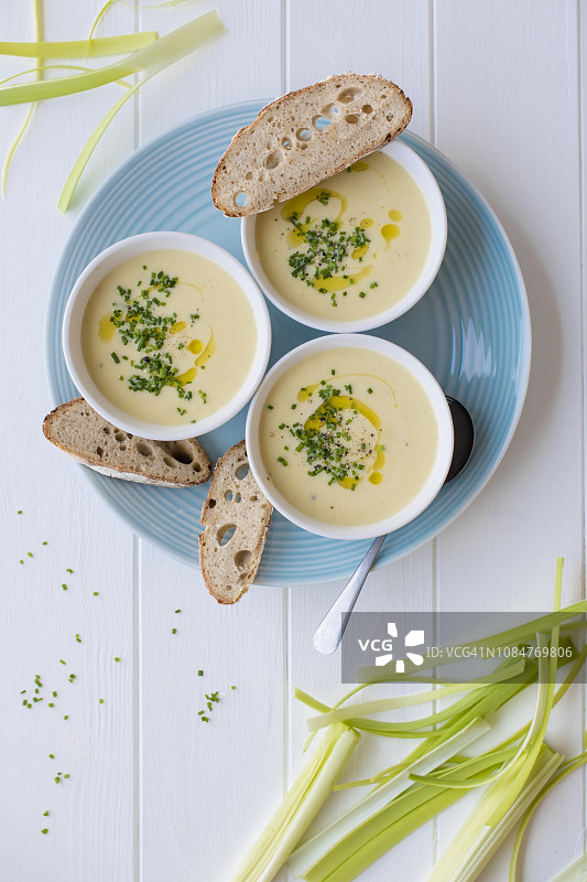 维希奶油浓汤（奶油韭葱和土豆），配橄榄油、新鲜韭菜和酸面包图片素材