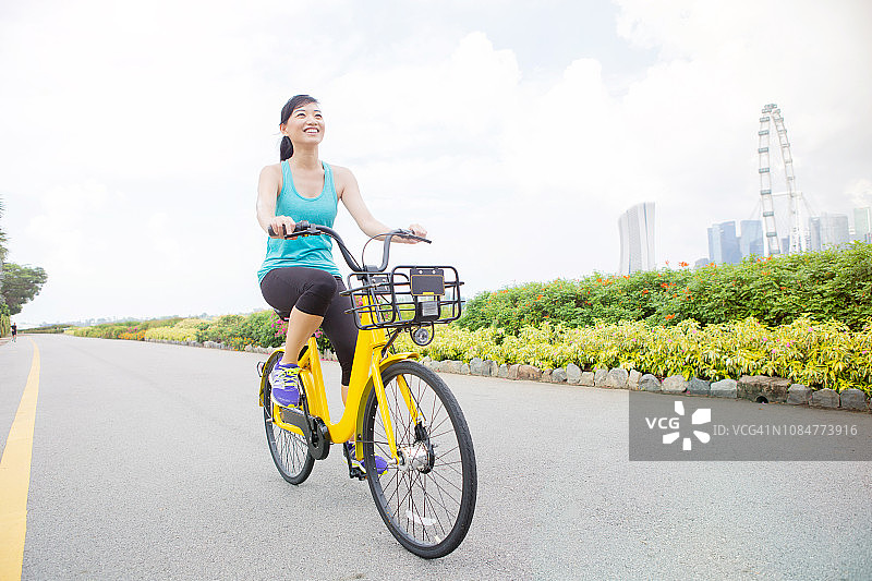 充满活力的中年妇女骑着租来的自行车图片素材