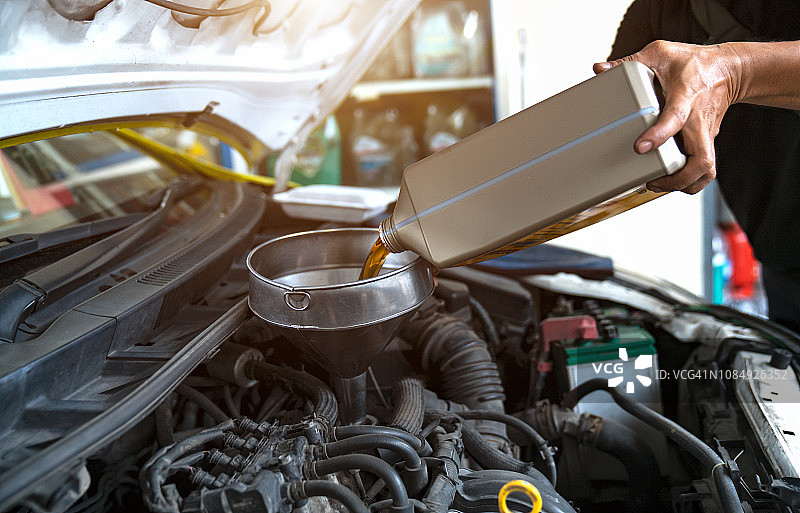 汽车修理工更换并向发动机注入新机油图片素材