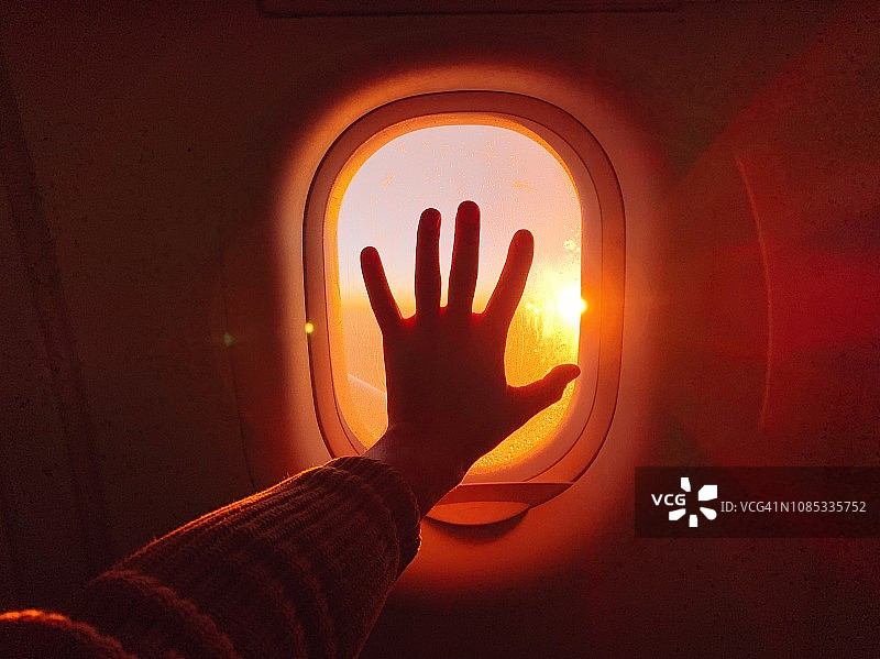 日落时分触摸飞机舷窗图片素材