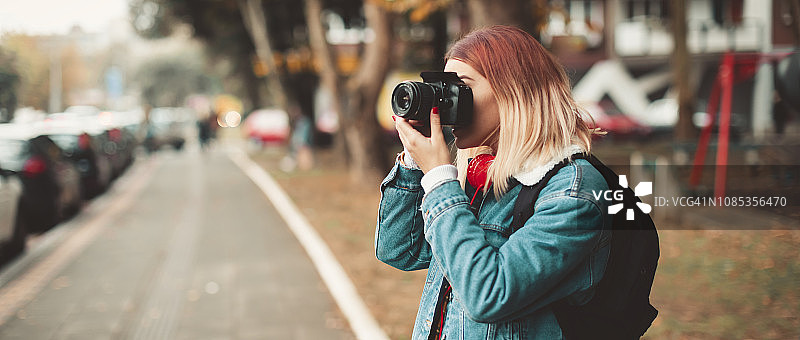 在街上用相机拍照的女人图片素材