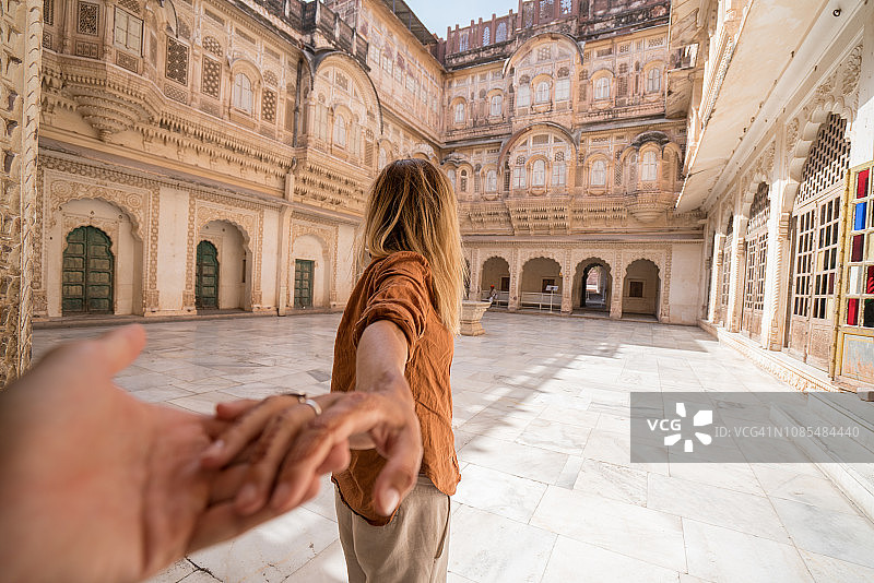 概念：日落时分，女子牵手男友在印度堡垒内图片素材