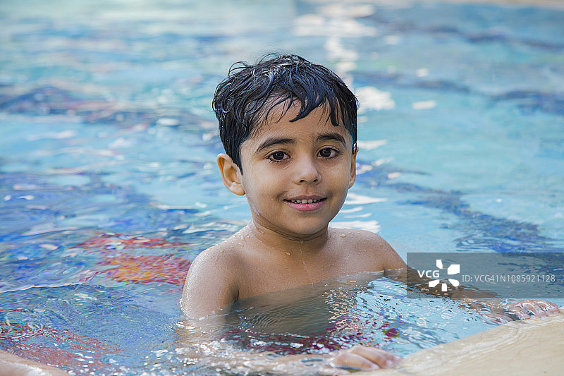 夏季泳池里快乐儿童的游泳活动图片素材