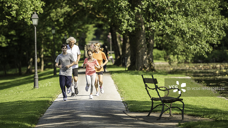 祖父母和孙子孙女在公园里跑步图片素材
